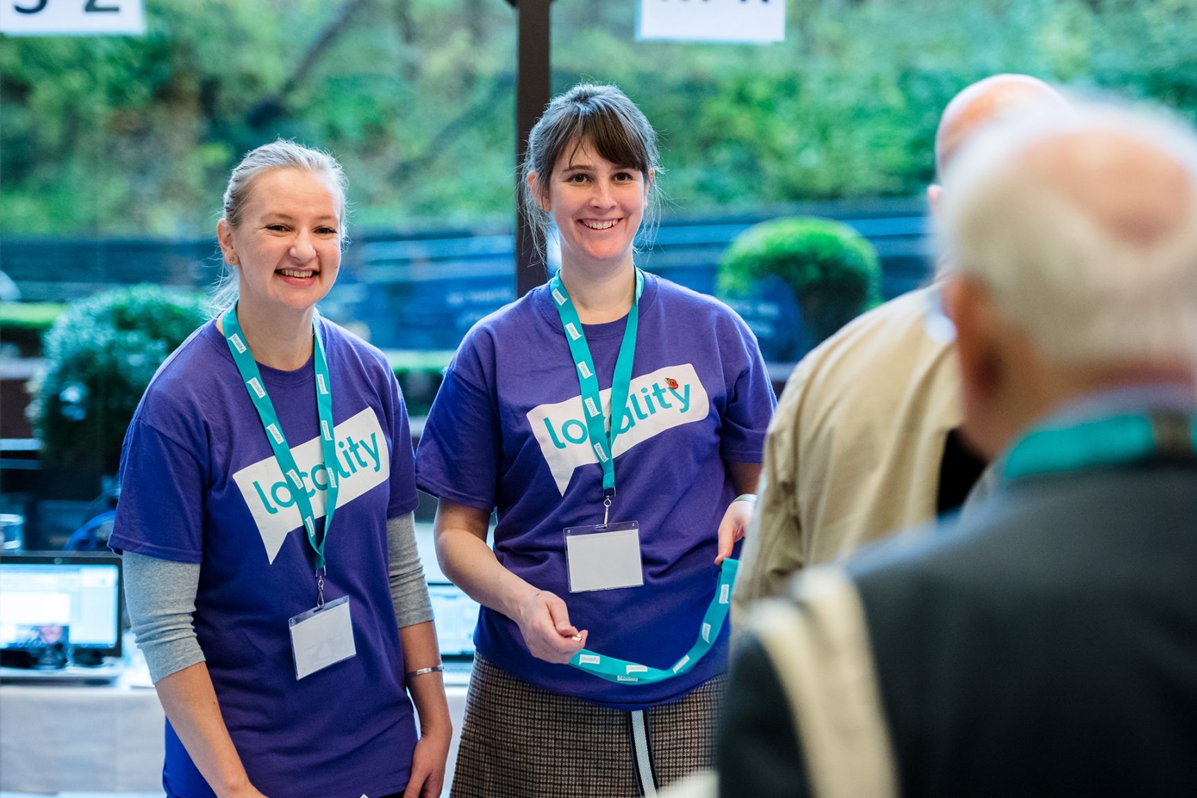 Two members of Locality wearing Locality t-shirts at an event