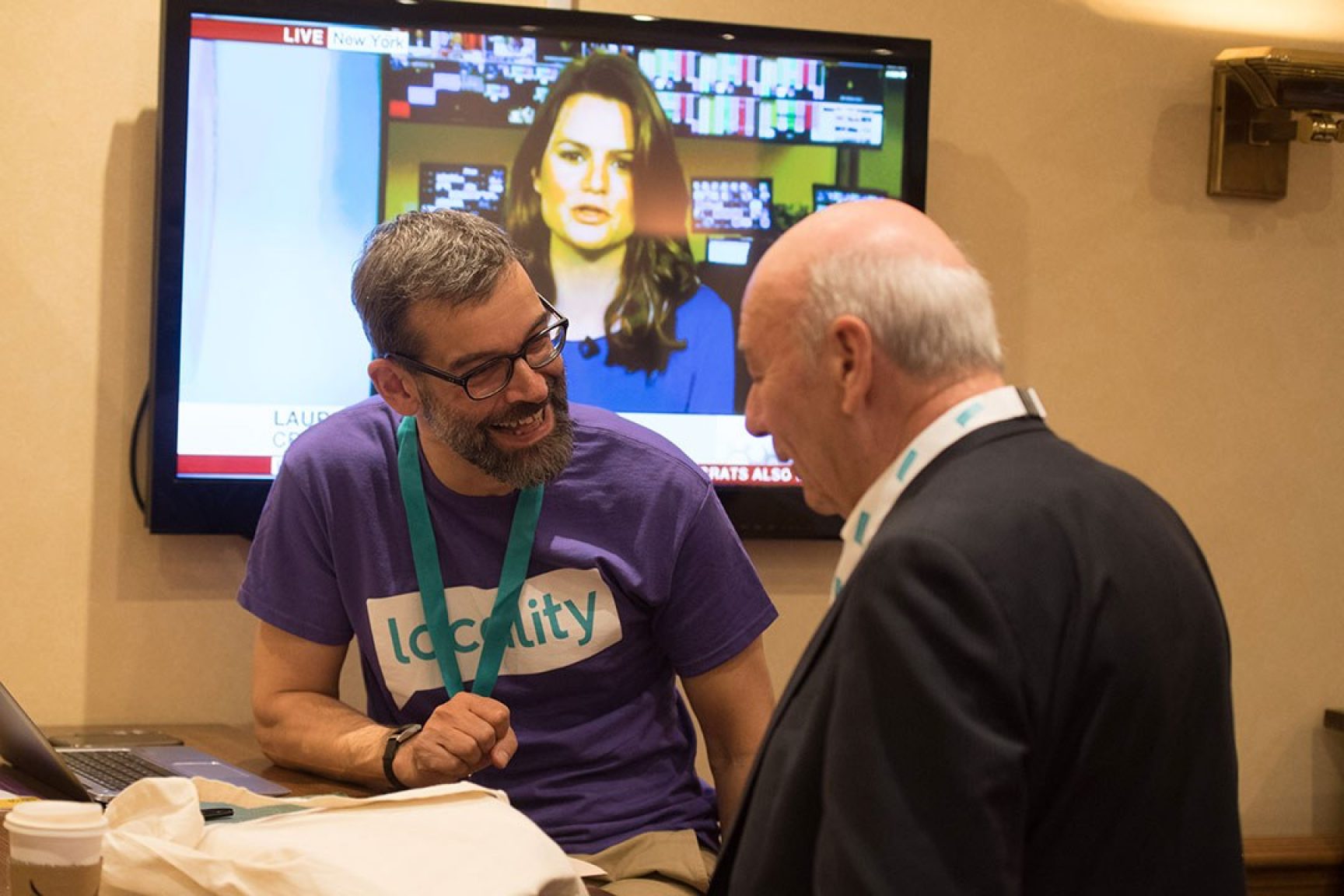 A Locality staff member chatting to a Locality member at an advice surgery. They are smiling.