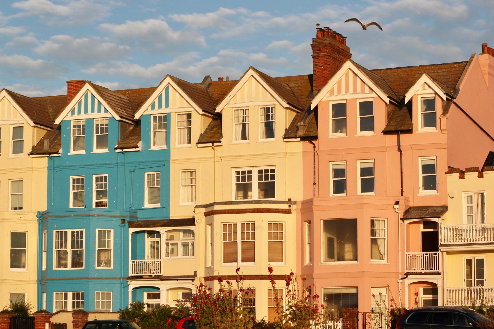 A row of different coloured houses glowing in the sunset