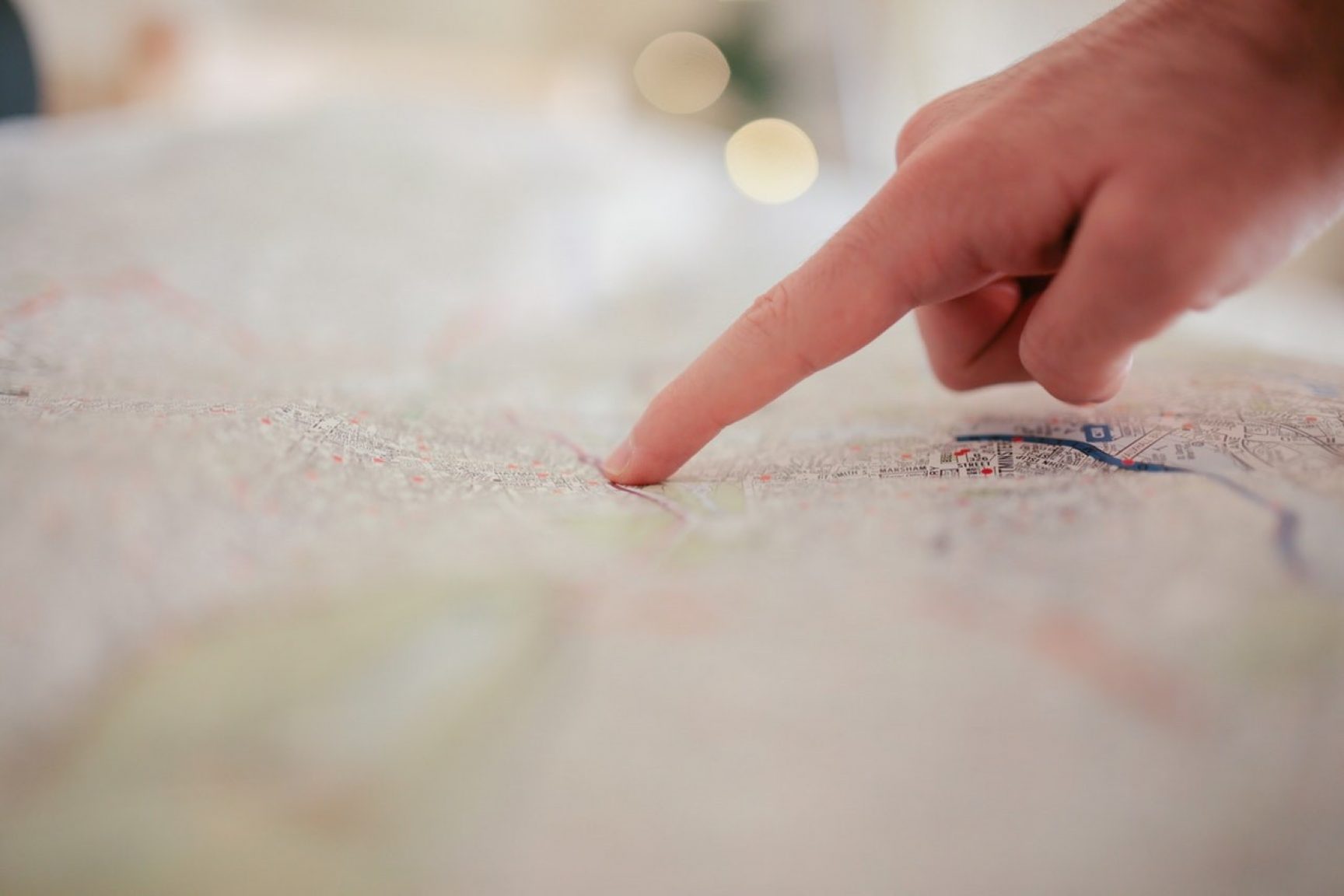 A hand pointing to something on a map.